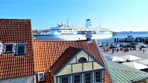 トラフェミュンデにあるRooming24, kleine Pensionの客船が建物のある桟橋に停泊