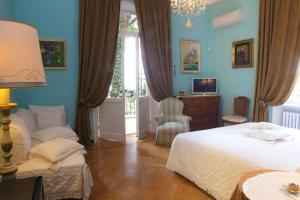 a bedroom with blue walls and a bed and a chair at La Casa di Anny camere di Charme Citr 8027 in Diano Marina