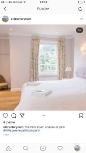 a bedroom with a white bed with a window at The Old Rectory in Campsey Ash