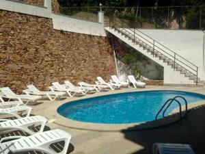 a group of chairs and a pool with chairs and stairs at Apartamento Puerto Blanes in Blanes +11 photos