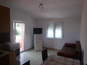 ein Wohnzimmer mit einem Sofa und einem Kühlschrank in der Unterkunft Apartmani Bartolić in Biograd na Moru