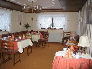 a dining room with tables and chairs and windows at Pension Kordula Straub in Waldfenster