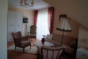 a living room with a couch and a table and chairs at Pension Kordula Straub in Waldfenster