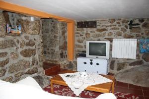 un soggiorno con tv e tavolo di Casa de Pedra a Viseu