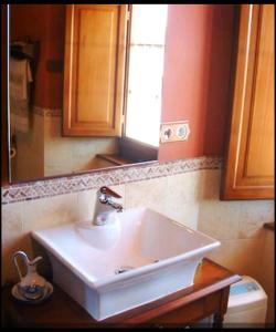 La salle de bains est pourvue d'un lavabo blanc et d'un miroir. dans l'établissement Casa Rural Oza dos Ríos, à Oza dos Ríos