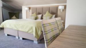 Schlafzimmer mit einem Bett und einem Holztisch in der Unterkunft Hotel Quellenhof in Grainau