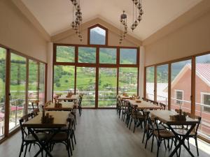 a restaurant with tables and chairs and large windows at Hamsikoy Hotel in Hamsikoy