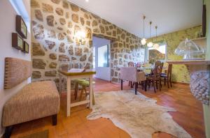 a living room with a table and chairs and a stone wall at Arrábida Mountain House in Azeitao