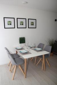 a dining room table with chairs and a white wall at Jakob8 in Blieskastel