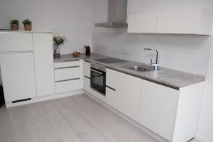 a white kitchen with white cabinets and a sink at Jakob8 in Blieskastel