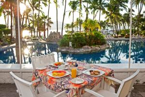 a table with food and drinks next to a swimming pool at Las Hadas by Brisas in Manzanillo