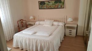a small bedroom with a bed with white sheets at Casa Bellavista in Segovia