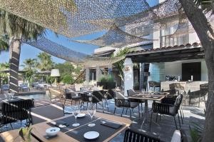 un restaurante con mesas y sillas en un patio en Hotel Boutique Ses Pitreras, en Port d'es Torrent