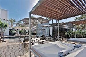 a patio with tables and chairs and umbrellas at Hotel Boutique Ses Pitreras in San Antonio Bay