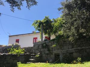 una casa detrás de una pared de piedra en Casa da Nave, en Monchique