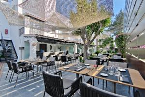 a restaurant with tables and chairs on a patio at Hotel Boutique Ses Pitreras in San Antonio Bay