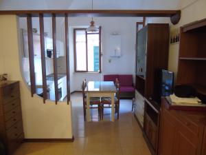 a kitchen and dining room with a table and a television at La casa sul mare in Riva Ligure