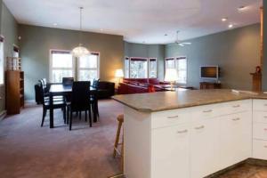 a kitchen and living room with a table and chairs at Vacation Homes by The Bulldog- Henk's Haven in Silver Star