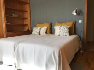 a bedroom with a large white bed with pillows at Varandas da Sandia in Vila Praia de Âncora