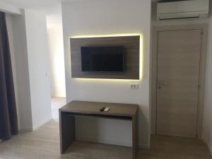 a living room with a table and a television on a wall at Belveder Deluxe Suite and Rooms in Supetarska Draga