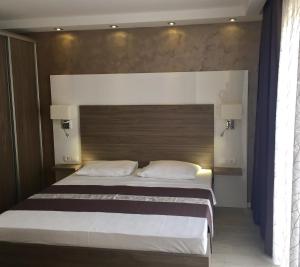 a bedroom with a large bed with two pillows at Belveder Deluxe Suite and Rooms in Supetarska Draga