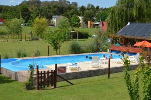 a swimming pool in a yard with a gazebo at Cabañas Tranquera 8 in Chascomús