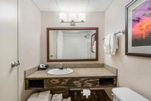 ein Badezimmer mit Waschbecken und Spiegel in der Unterkunft Ramada Plaza by Wyndham Nags Head Oceanfront in Kill Devil Hills