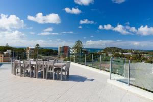 een patio met een tafel en stoelen op een balkon bij Sevan Apartments Forster in Forster