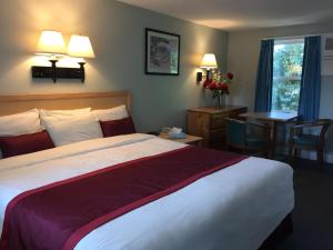 une chambre d'hôtel avec un lit, une table et une fenêtre dans l'établissement The Cutty Sark, à Dennis Port