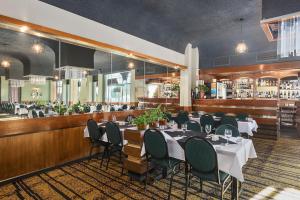 a restaurant with tables and chairs and a bar at Beachfront Voyager Motor Inn in Burnie