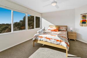 a white bedroom with a bed and a window at Cloud Nine in Rye
