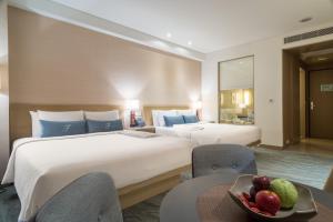 a hotel room with two beds and a bowl of fruit at Fleur de Chine Hotel in Yuchi