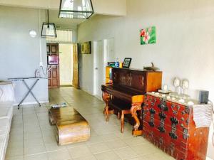 a living room with a piano and a bench at Room With A View & Apartment Style in Port Vila