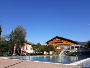 a large swimming pool in front of a building at Landhotel Häuserl im Wald in Gröbming