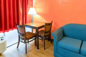 um quarto com uma mesa e cadeiras e um sofá em Motel 6-Groton, CT - Casinos nearby em Groton