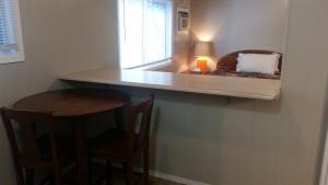a kitchen with a counter with a table and a mirror at Holiday House Motel in Penticton