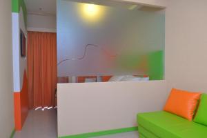 sala de estar con sofá verde y naranja en Titanium Express HomTel en Yakarta