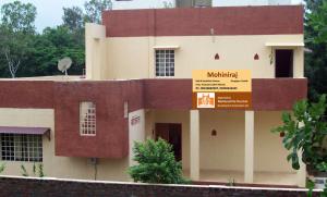 a building with a sign in front of it at MTDC Approved Mohiniraj Guest House in Nashik +7 photos