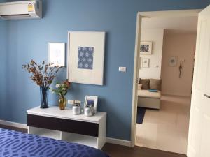 a bedroom with a blue wall with a table and a mirror at Condo BaanTiewLom by Sipa in Cha Am +9 photos