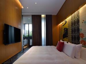 a bedroom with a large bed and a flat screen tv at The Sun Hot Spring & Resort in Taichung