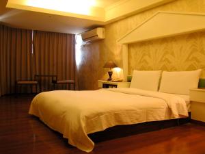 a bedroom with a large white bed in a room at Zaw Jung Business Hotel in Taichung