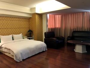 a hotel room with a bed and a chair at Zaw Jung Business Hotel in Taichung +28 photos