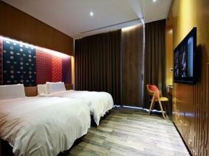 a bedroom with a bed and a television at The Sun Hot Spring & Resort in Taichung