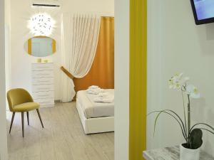 塔蘭托的住宿－Duca70 "Suite Home"，一间卧室配有一张床、镜子和椅子