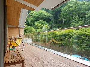 a balcony with a bench and a large window at Yadori Onsen Iyashinoyu in Hashimoto