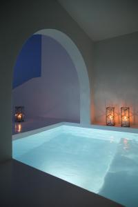 a large swimming pool with lights in a room at Vino Houses in Oia