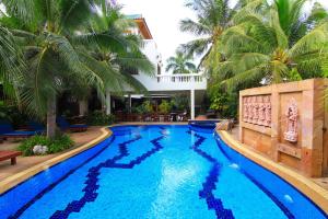 una piscina en un complejo con palmeras en Hua Hin Golf Villa, en Hua Hin