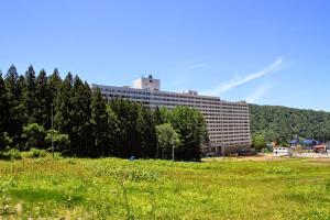 a large building in the middle of a field at Hotel Angel Grandia Echigo Nakazato in Yuzawa