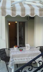 uma mesa com uma toalha de mesa branca num pátio em Katerinas Apartments em Neos Marmaras