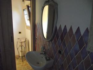 Casa Marcella Cugnana-Portisco في كوغنانا: حمام مع حوض ومرآة